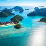 Labuan Bajo coastline with villas and clear blue water.